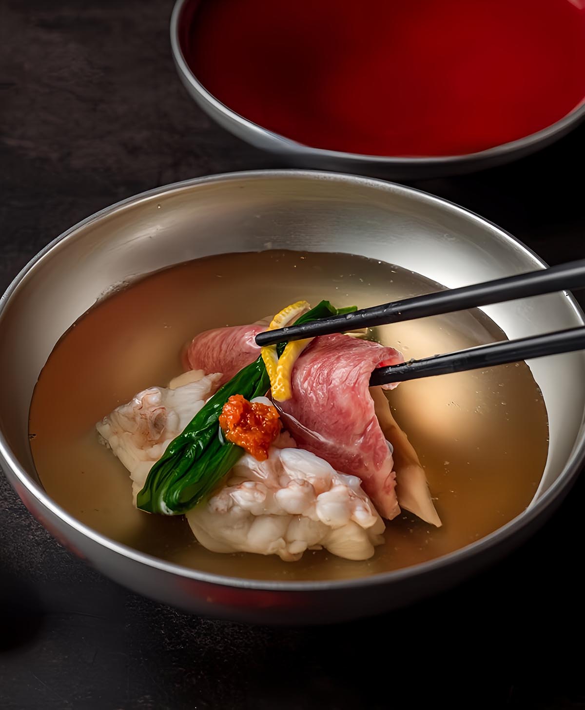 Wagyu Sukiyaki with Wagyu striploin, napa cabbage, chrysanthemum, tofu, and mushrooms